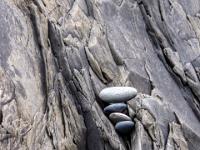 Kieselsteine in einer Spalte an geschichteten Felswand